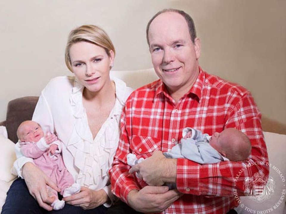 Prinz Albert in rot-weiss-karriertem Hemd, Prinzessin Charlàne in weiss, beide halten je ein Baby im Arm