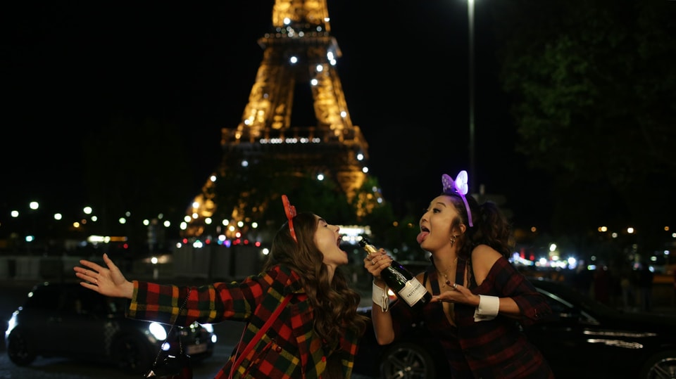 zwei Frauen, die vor dem Eiffelturm Grimassen schneiden