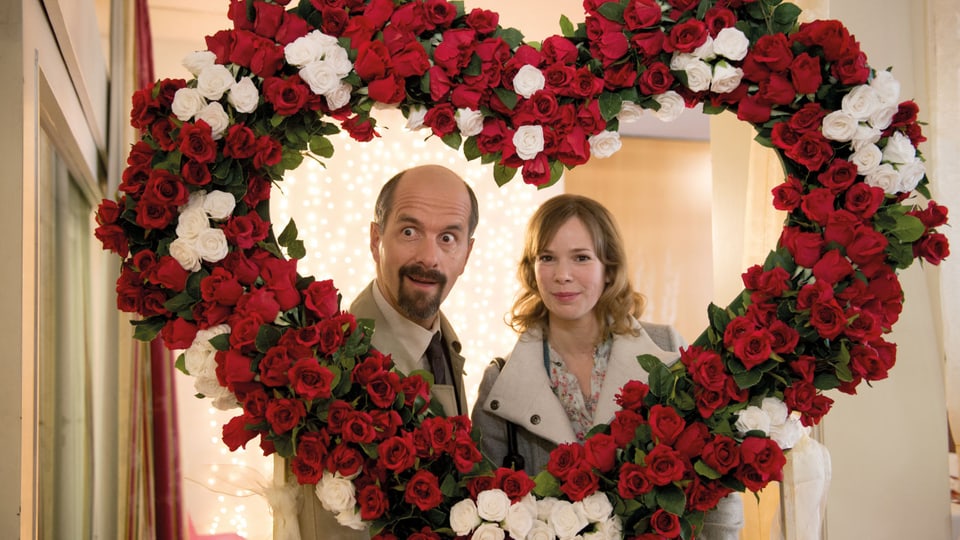 Stromberg mit seiner Angebeteten hinter einem gigantischen Herz aus roten und weissen Rosen.