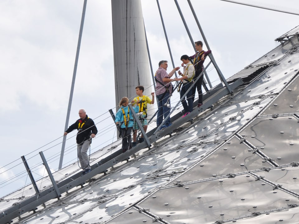 Touristen gehen über das Olympiadach.