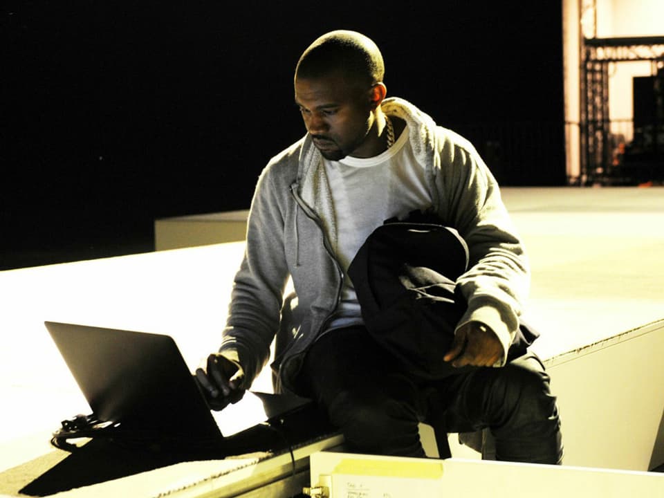 Kanye West schaut in seinen Laptop an der Art Basel.