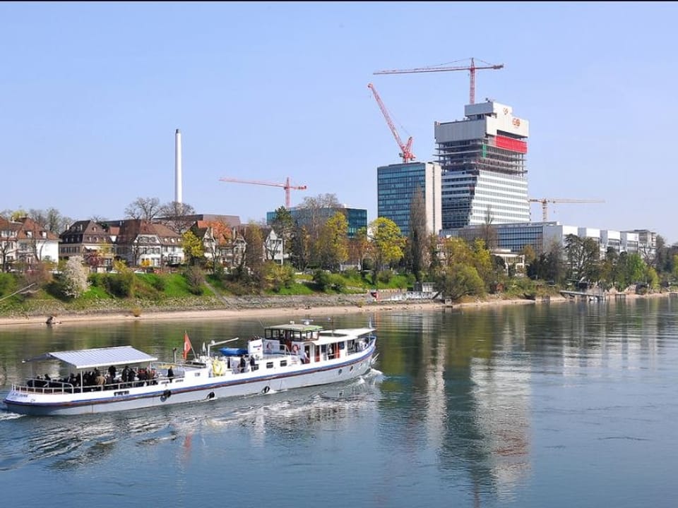 Ein Schiff auf dem Rhein, im HIntergrund der Rocheturm im Bau