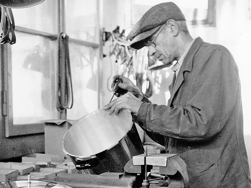 Altes Bild: Ein Mann montiert einen Dampfkochtopf.