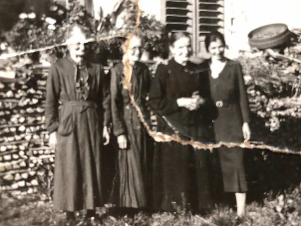 Eine schwarz-weiss Aufnahme mit vier Personen die nebeneinander stehen.