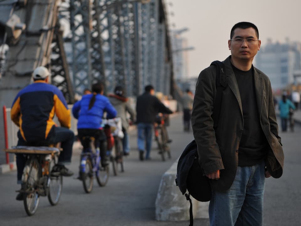 Chang Ping steht auf einer Brücke.
