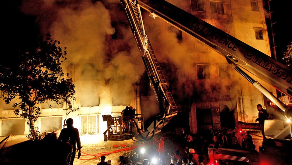 Feuerwehrleute löschen einen Grossbrand in einer Fabrik in Bangladesch. (keystone)