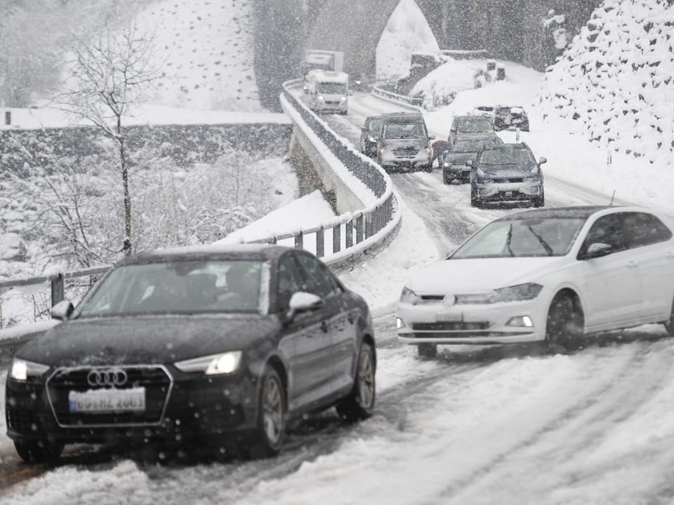 Autos auf der schneebedeckten Strasse in Faido