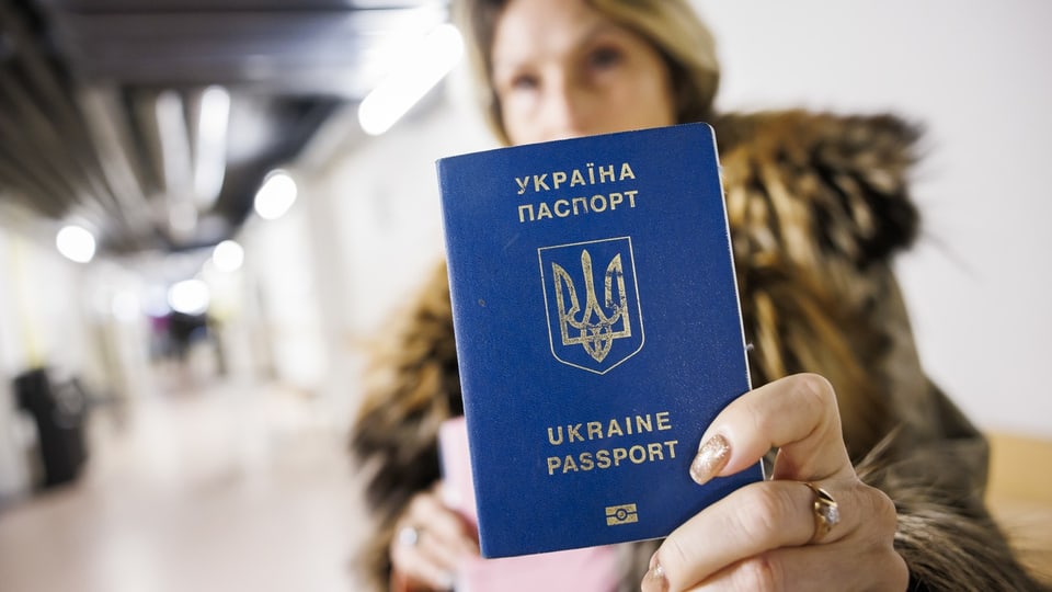 Frau hält ukrainischen Pass in Kamera