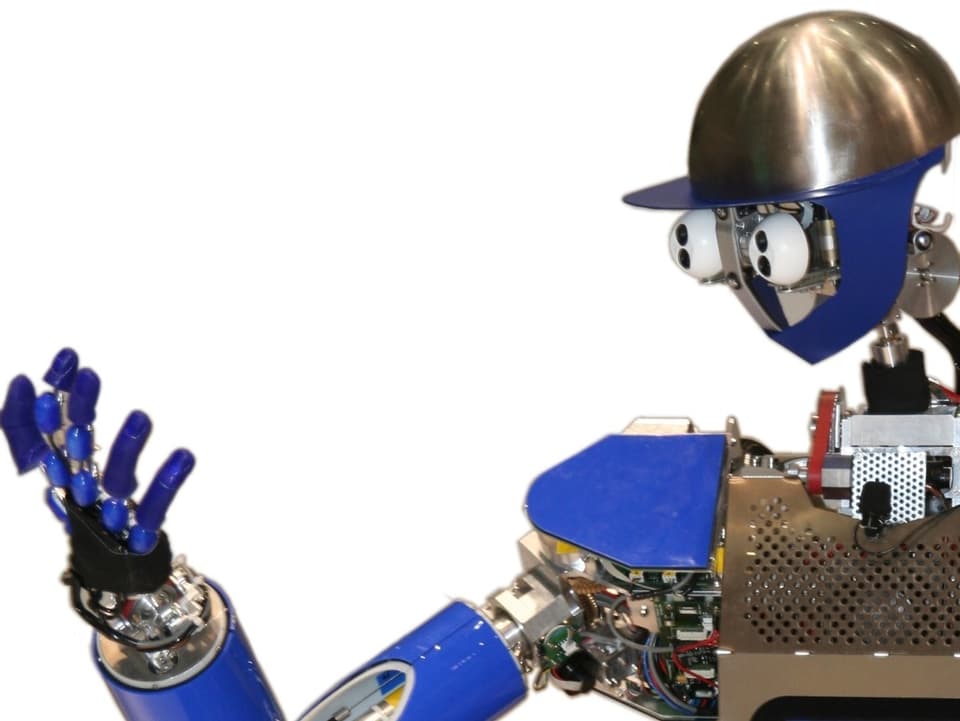 Ein Roboter namens Armar mit Metallmütze und ausgestrecktem Arm.