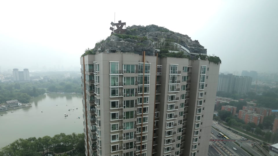 Ein Haus in Peking mit einem Berg auf dem Dach.