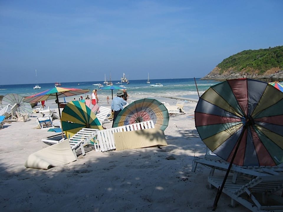 Sonnenschirme und Liegestühle liegen umgestossen am Strand.