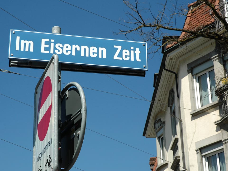 Auf einem blauen Strassenschild steht der Name «Im Eisernen Zeit».