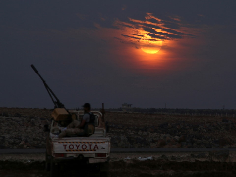 Rebellenkämpfer in Syrien, hinter ihm der Mond. 