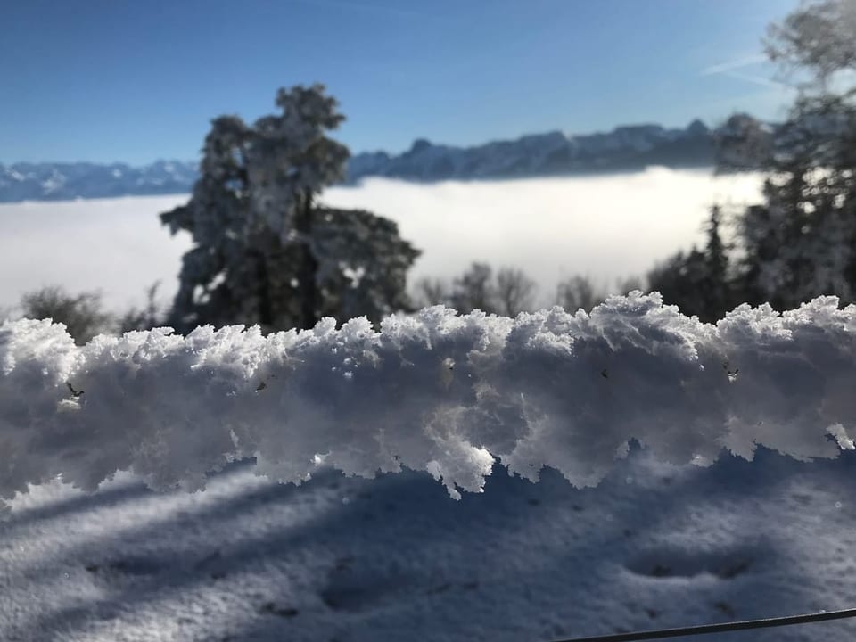 Raueis bildete sich am Zaun vor der schönen Kulisse über dem Nebelmeer.