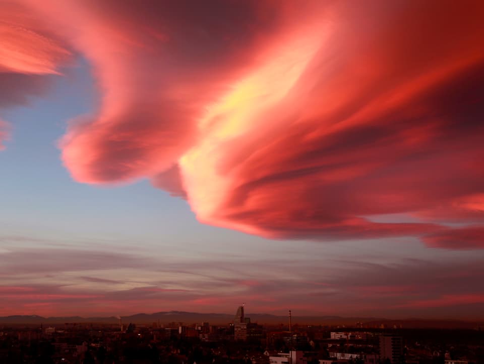 Eine riesige farbige Wolke sieht aus wie ein Ufo über der Stadt Basel.