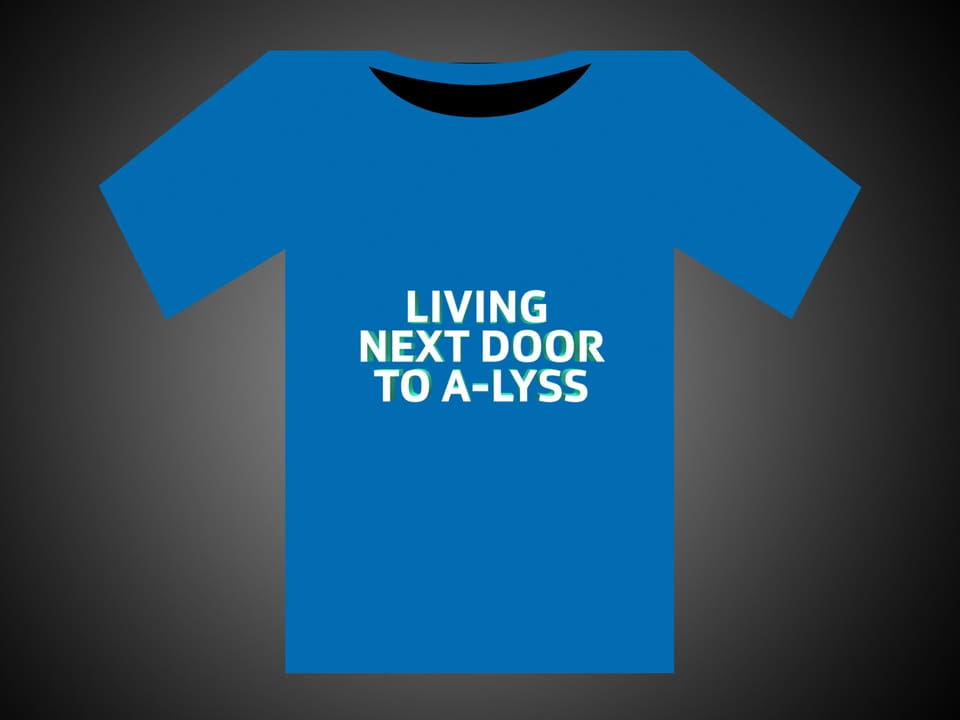 Weisse Schrift auf blauem T-Shirt: Living Next Door To A-Lyss.