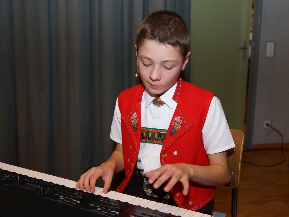 Der junge Musikant spielt Piano.