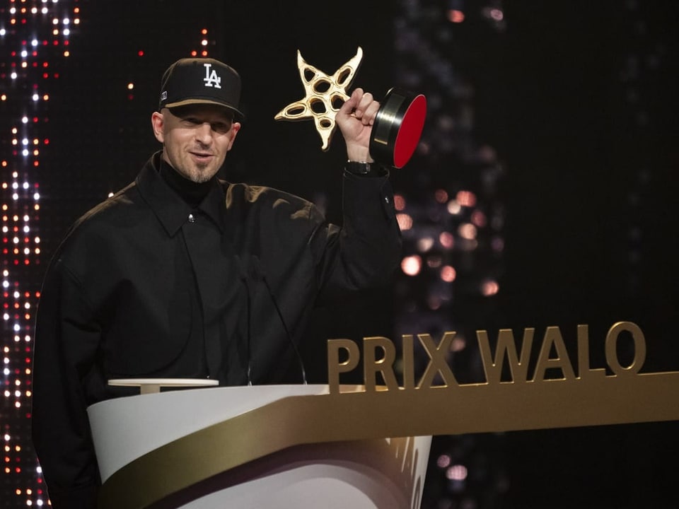 Mann in Kappe hält Trophäe bei der Prix Walo-Verleihung