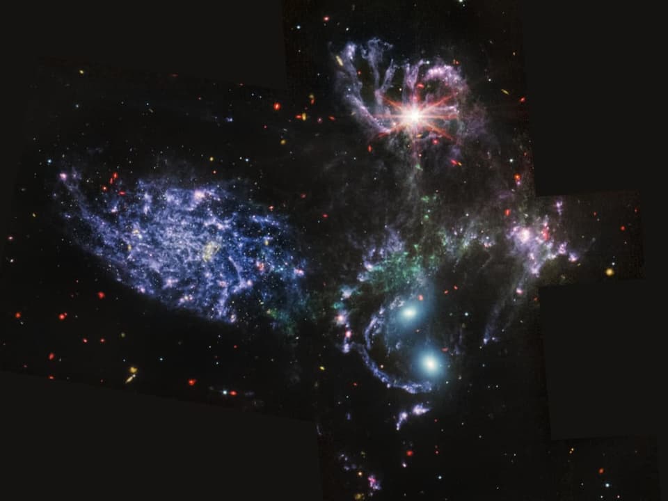 Fünf unterschiedlich gefärbte Galaxien im All.