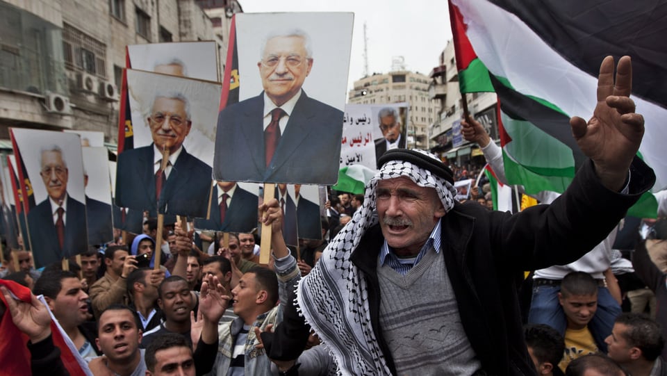 Palästinenser demonstrieren mit Fahnen und Bildern von Abbas.