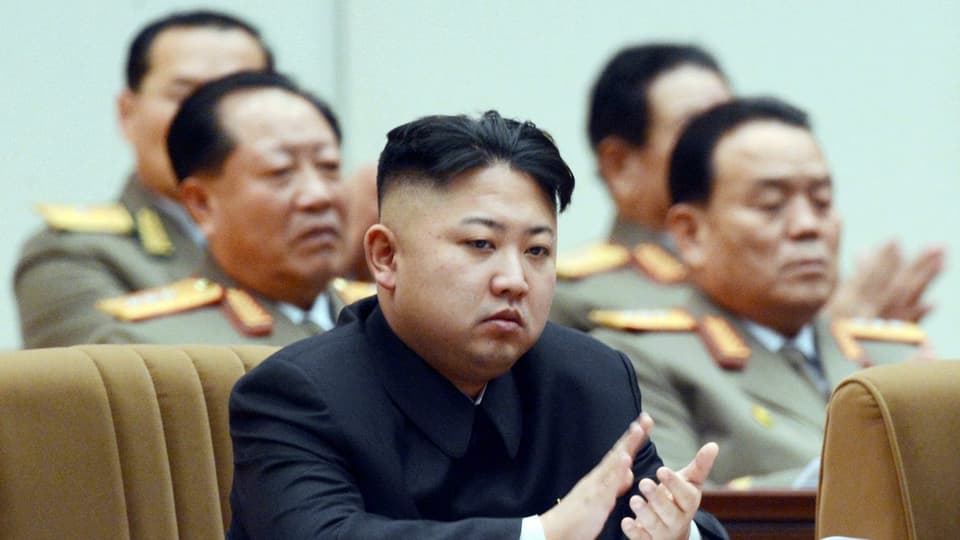 Kim Jong Un sitzt mit Armeeführern und klatscht