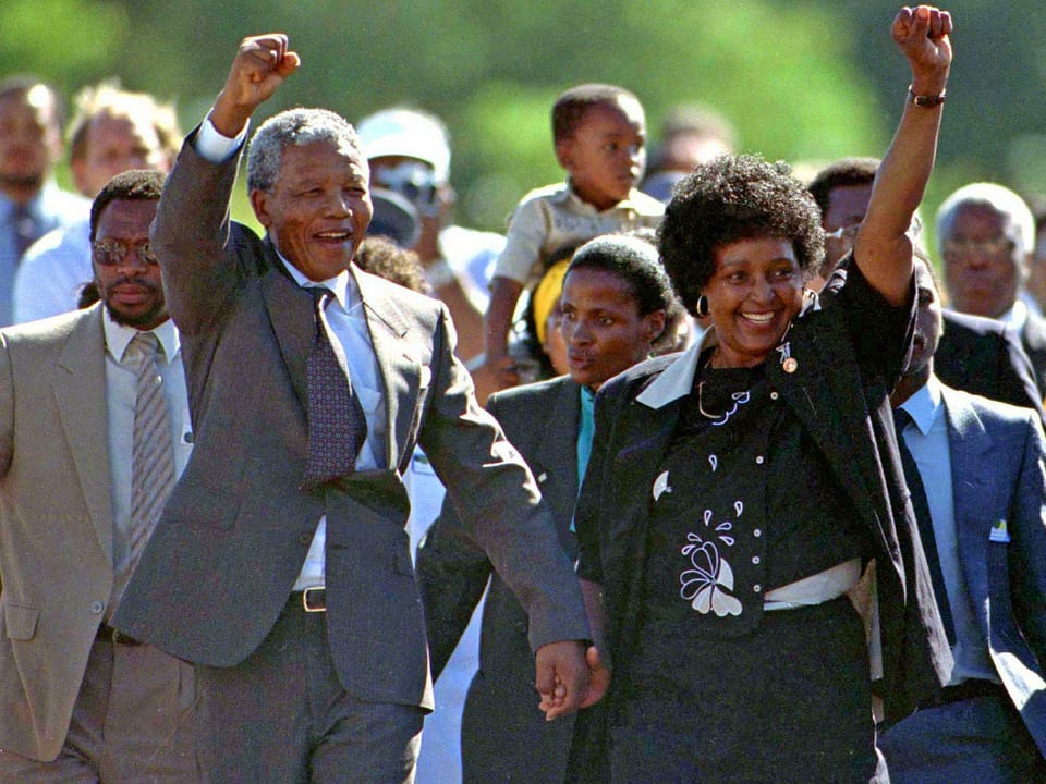 Mandela und seine Frau strecken die Faust in die Höhe.