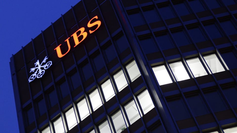 Gebäude in der Nacht mit einem leuchtenden UBS-Logo.