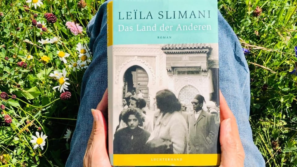 Buchtipp Nummer 4 Das Buch «Das Land der Anderen» von Leïla Slimani liegt auf Annette Königs Knien
