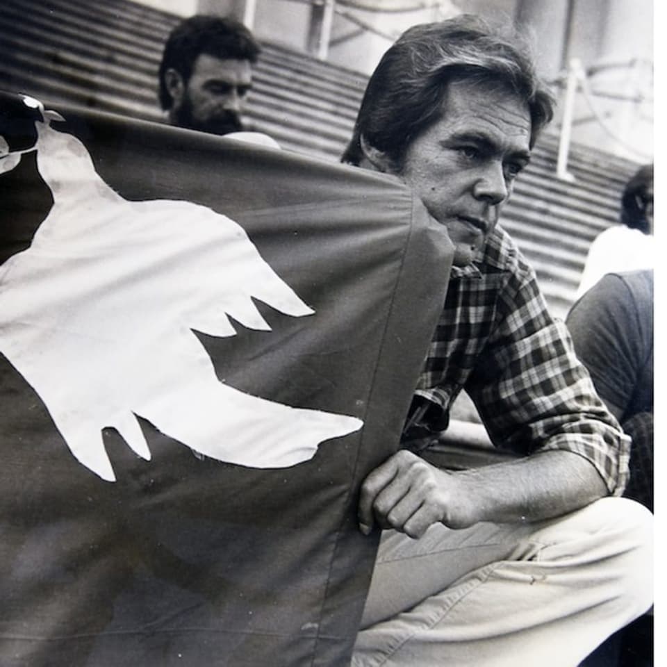 Schwarz-Weiss-Foto von einem Mann mit einer Flagge in der Hand