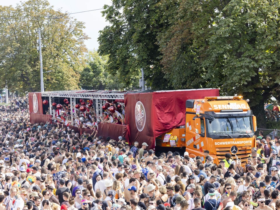 Ein Lastwagen steht in einer grossen Menschenmenge. Der Anhänger ist eine Tanzfläche.