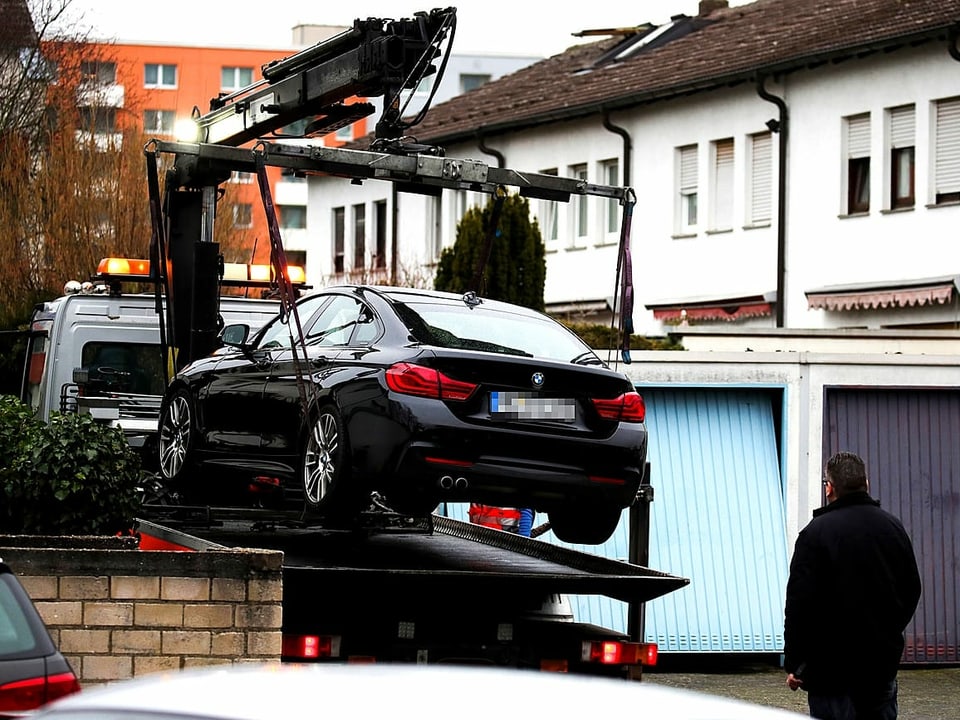 Ein BMW wird mit einem Kran auf einen Abschleppwagen gehoben im hessischen Hanau.