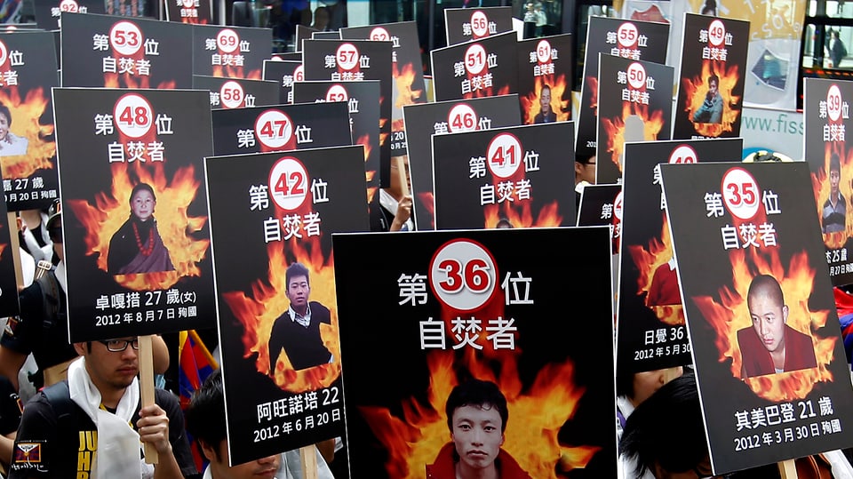 Menschen protestieren gegen Chinas Politik.