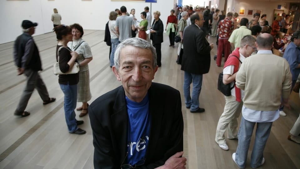 Mann älteren Alters steht im Foyer der Fondation Beyeler in Basel. Hinter ihm tummeln sich Menschen, die eine Ausstellung besuchen wollen.