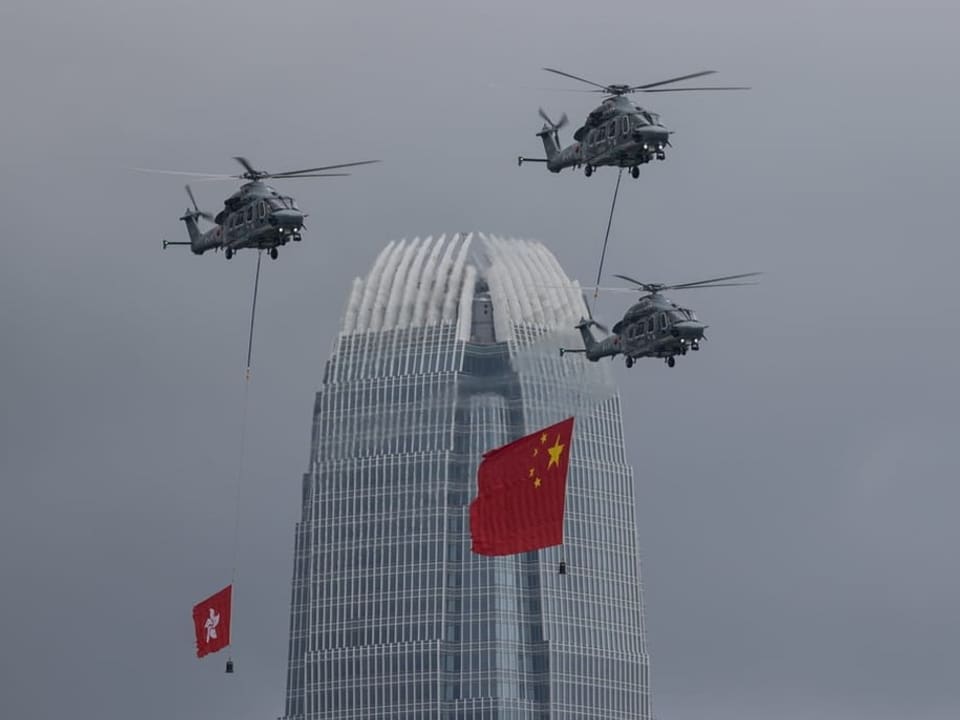 Helikopter des staatlichen Flugdienstes zeigen die Flaggen der VR China und der Sonderverwaltungszone Hongkong.