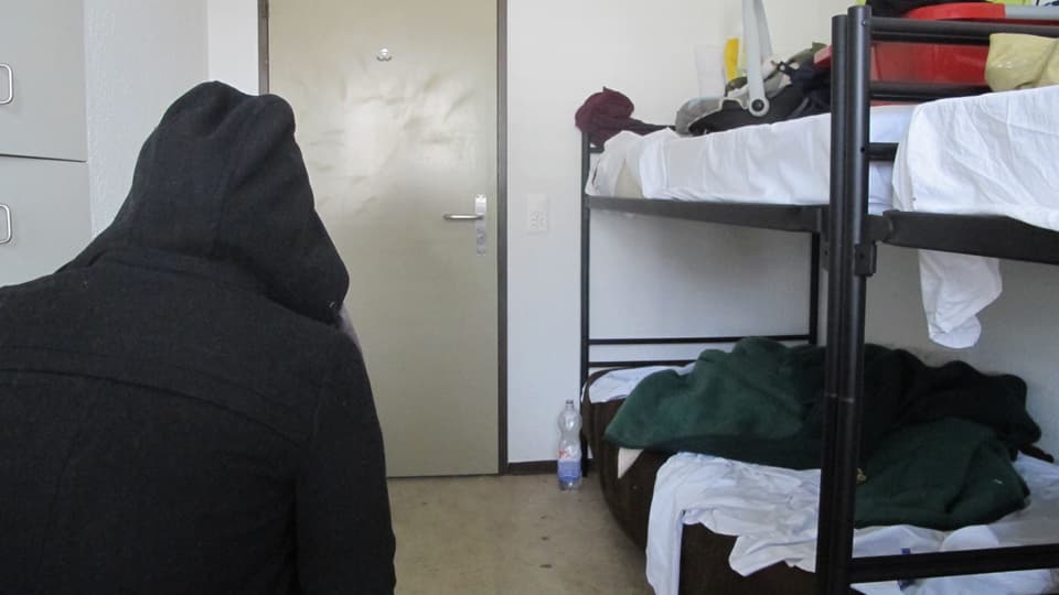 Ein Asylbewerber sitzt in einem Zimmer einer Asylunterkunft in der Region.
