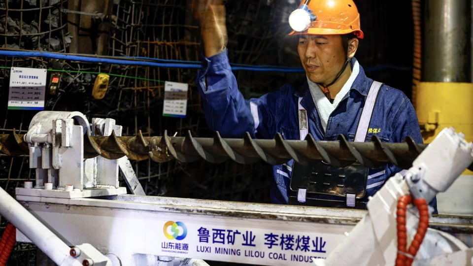 Ein Arbeiter hantiert an einer Maschine in einer chinesischen Kohlemine.