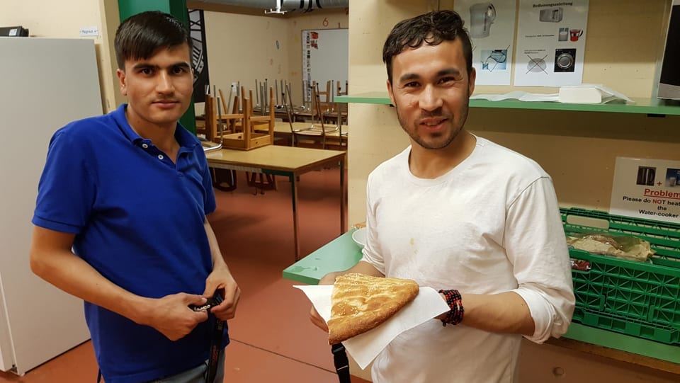 Zwei Männer halten ein Brot