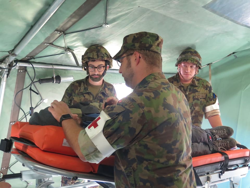 Ein Militärarzt untersucht einen Patienten in einem Sanitätszelt. 