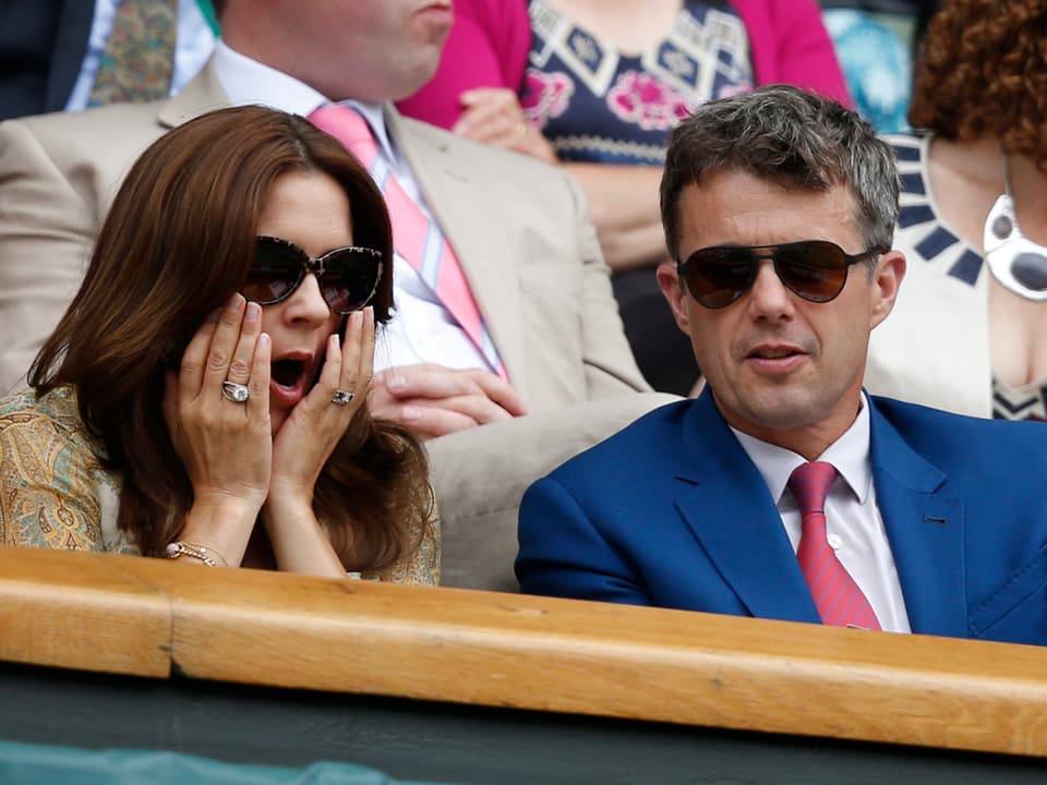 Kronprinzessin Mary und Kronprinz Frederik von Dänemark sitzen und staunen auf der Tribüne vom Wimbledon-Turnier in London.