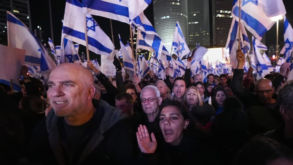 Zahlreiche Menschen und Israel-Flaggen sind auf dem Bild zu sehen.