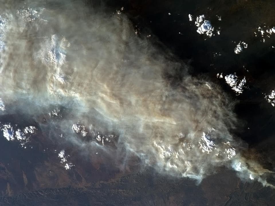 Ein Foto aus dem All. Zu sehen ist eine dicke Rauchdecke über Australien.