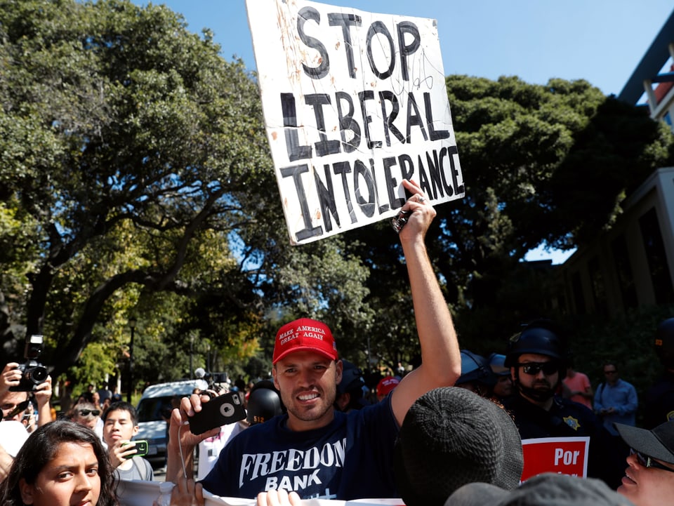 Ein Demonstrant hält ein Schild mit der Aufschrift "Stop liberal intolerance" hoch.