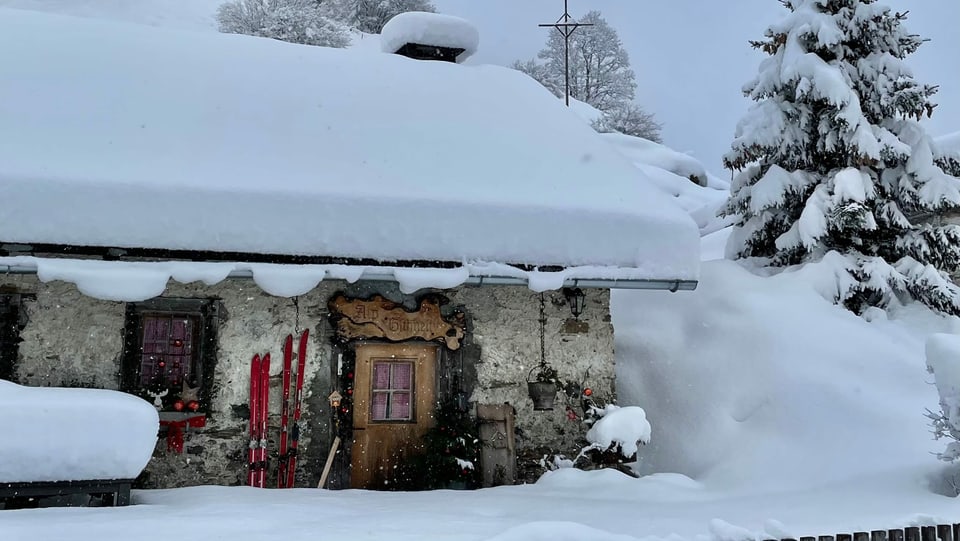 Eine Hütte versinkt fast im vielen Neuschnee.