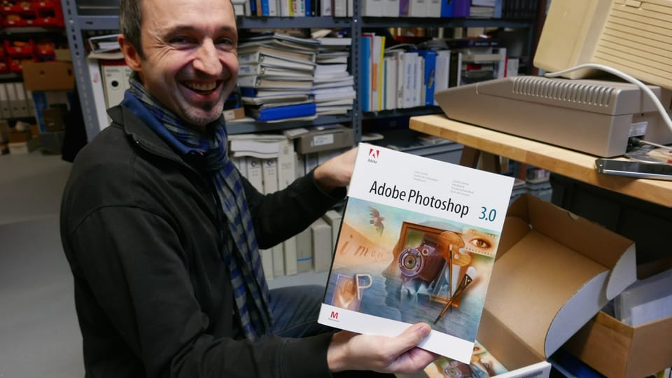 Reto Bösch vom «Enter» in Solothurn mit einem Originalhandbuch von Photoshop 3.0.