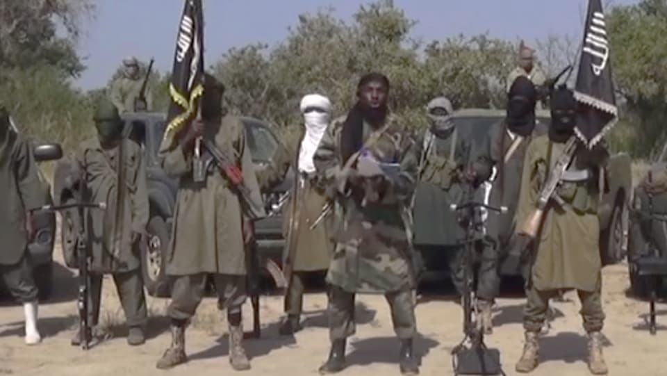 Gruppe von maskierten Boko-Haram-Mitgliedern vor ihren Trucks
