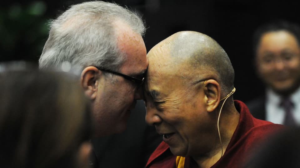 Der Dalai Lama und ein älterer Herr berühren sich gegenseitig mit der Stirn