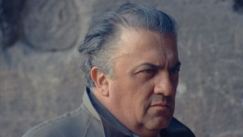 Federico Fellini im Porträt mit kritischem Blick.