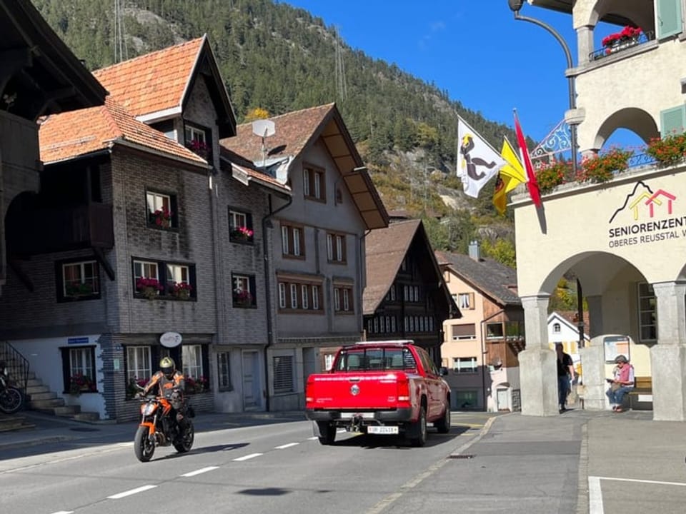 Ein Töfffahrer und ein Pickup fahren durch Wassen.