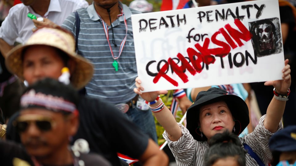 Eine Demonstrantin hält ein Anti-Thaksin-Schild in die Höhe: «Todesstrafe für Korruption».