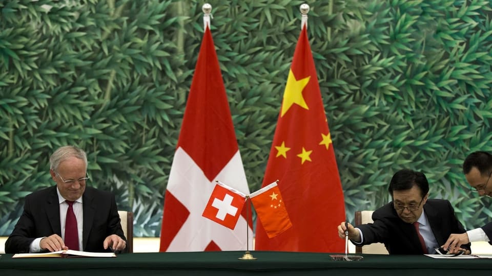 Johann Schneider-Ammann und der chinesische Handelsminister unterzeichnen Dokumente.